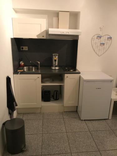 a small kitchen with a sink and a stove at Apartment de Boer in Zandvoort