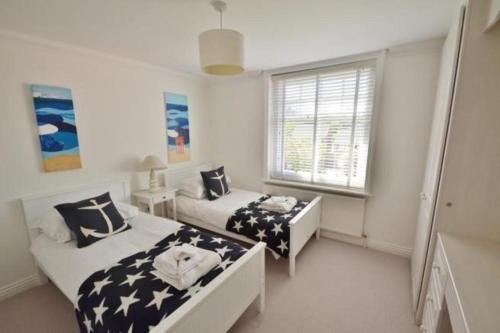 1 dormitorio con 2 camas y ventana en Springhill House, en Swanage