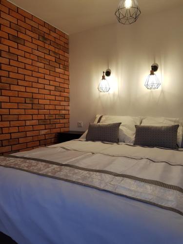een slaapkamer met een groot bed met een bakstenen muur bij MISVEST Maria IV Arena Gliwice in Gliwice