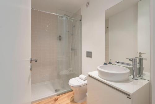 La salle de bains est pourvue de toilettes, d'un lavabo et d'une douche. dans l'établissement LovelyStay - Quiet & Modern Loft minutes away from iron bridge, à Porto
