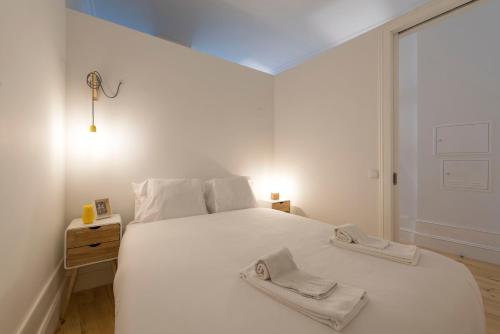 - une chambre avec un lit blanc et 2 serviettes dans l'établissement LovelyStay - Quiet & Modern Loft minutes away from iron bridge, à Porto