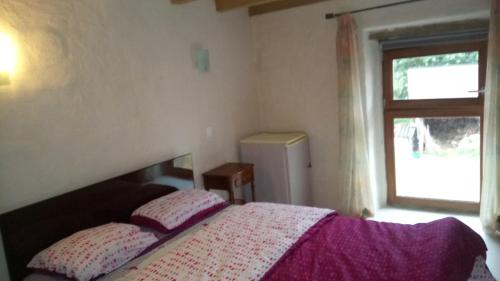 a bedroom with a bed with two pillows and a window at Le Clos Doré Parc in Bains-sur-Oust