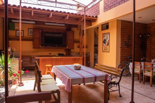 eine Terrasse mit einem Tisch und Stühlen sowie einem TV in der Unterkunft Casa Huéspedes Pimentel in Pimentel