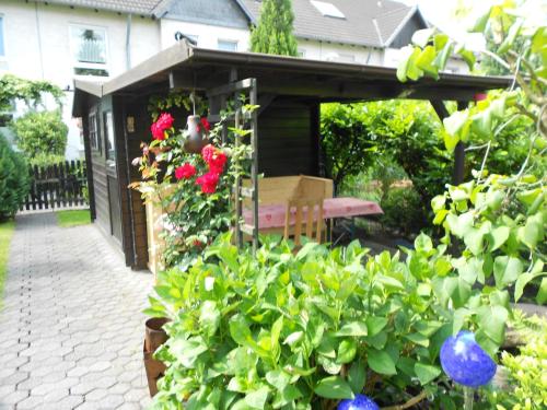 a garden with a bench and flowers in a yard at Apartment Airport in Cologne