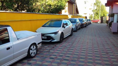 a row of parked cars parked on a street at Casa Leucian in Deva