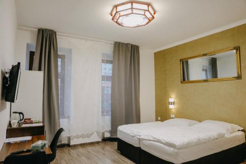 a bedroom with a bed and a mirror and a window at OASIS Teplice in Teplice