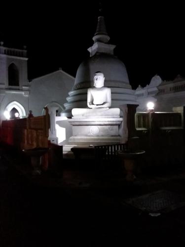 a large statue in front of a building at night at Sirène Galle Fort in Galle
