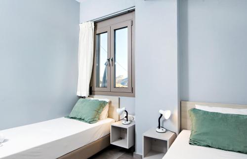a bedroom with two beds and a window at Villa Aias in Plakias