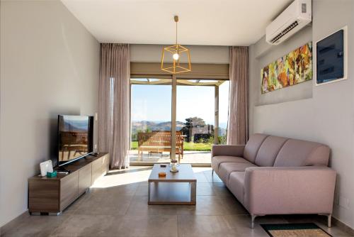sala de estar con sofá y TV en Villa Aias en Plakias