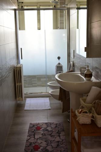 a bathroom with two sinks and a glass door at MADRIGIO... a casa propria in Casamassima