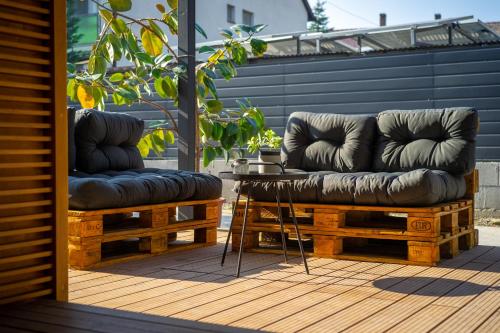 two bean bag chairs sitting on a deck with a table at A16 Design Panzió in Harkány