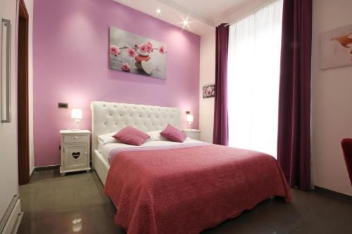 a bedroom with pink walls and a pink bedspread at Vatication B&B in Rome