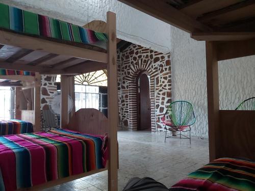 een kamer met 2 stapelbedden en een stoel bij El Sunset Hostel in Puerto Vallarta