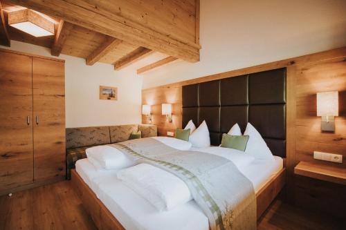 sypialnia z dużym białym łóżkiem z czarnym zagłówkiem w obiekcie Appartements Wieshof w mieście Sankt Johann im Pongau