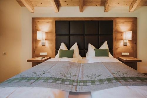 a bedroom with a large bed with a large headboard at Appartements Wieshof in Sankt Johann im Pongau