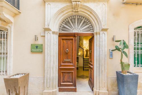 an entrance to a building with a wooden door at Modica for Family - Rooms and Apartments in Modica