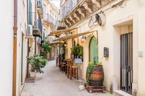 an alley in an old town with tables and chairs at Modica for Family - Rooms and Apartments in Modica