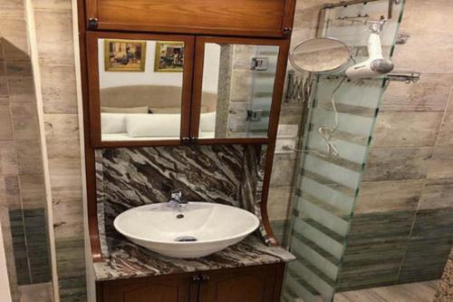 a bathroom with a sink and a mirror at Paris Hotel Cairo in Cairo
