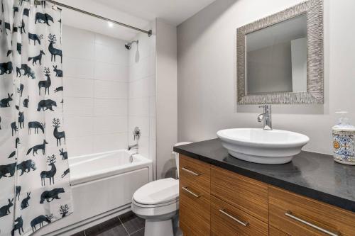 y baño con lavabo, aseo y cortina de ducha. en INITIAL - L'OURS - Mont-Sainte-Anne, en Beaupré