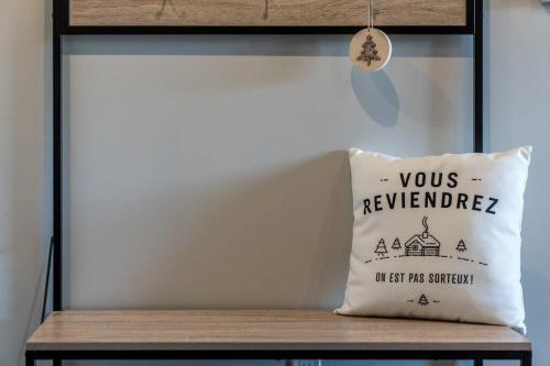 a pillow sitting on top of a wooden bench at INITIAL - L'OURS - Mont-Sainte-Anne in Beaupré