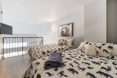 a bedroom with two beds with black dinosaur pillows at INITIAL - L'OURS - Mont-Sainte-Anne in Beaupré