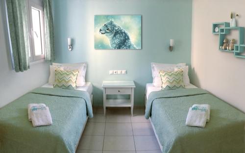 a room with two beds and a picture of a wolf at Haris Hotel Apartments and Suites in Paralia Vrachou