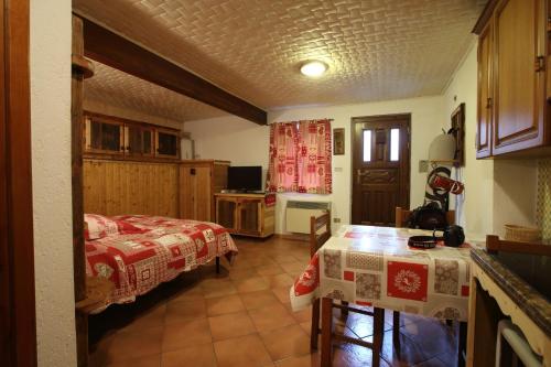 Un dormitorio con una cama y una mesa. en La Belette, en La Thuile