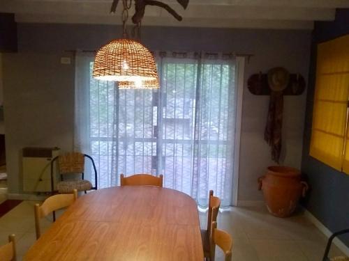 a dining room with a wooden table and a window at Shangri la in Mendoza