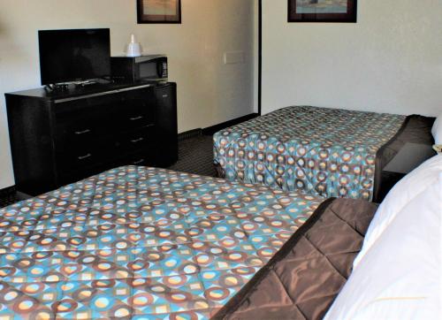 a hotel room with two beds and a tv at Knights Inn Payson in Payson