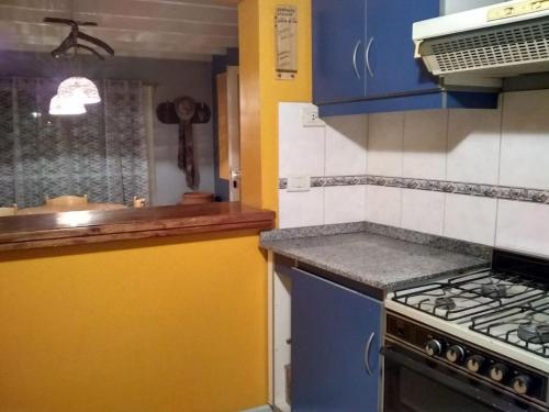 a kitchen with blue and yellow cabinets and a stove at Shangri la in Mendoza