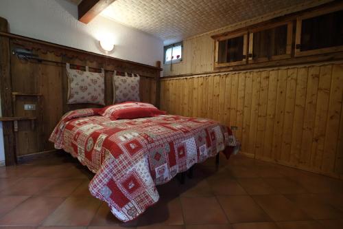 una camera con un letto con una coperta rossa e bianca di La Belette a La Thuile