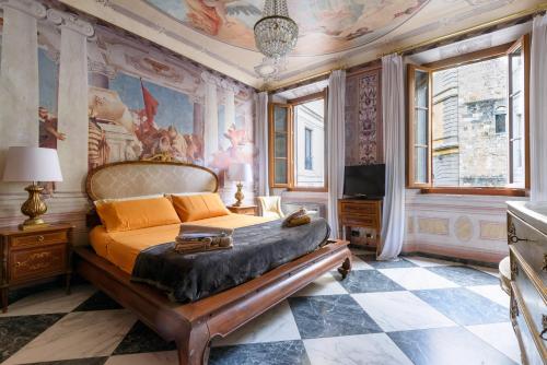 1 dormitorio con 1 cama con una pintura en la pared en Domus Nannini SPA - Palazzo Nannini, en Siena