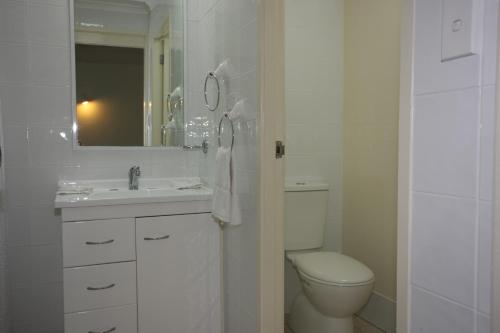 een witte badkamer met een toilet en een wastafel bij Tuncurry Lakes Resort in Tuncurry
