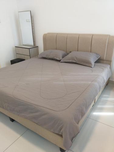 duże łóżko w sypialni z białą ścianą w obiekcie D Summit Cozy Homestay w mieście Skudai