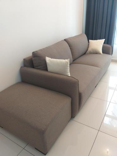 a brown couch with two pillows on it in a room at D Summit Cozy Homestay in Skudai