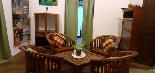 a dining room with a table and four chairs at Arachiwil Green Nature Resort in Puttalam