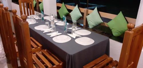 a table with a black table cloth and green pillows at Arachiwil Green Nature Resort in Puttalam