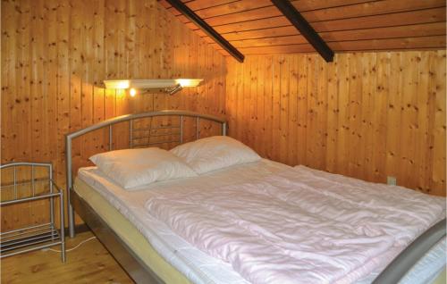 łóżko w pokoju z drewnianą ścianą w obiekcie Gorgeous Home In Ansager With Kitchen w mieście Ansager