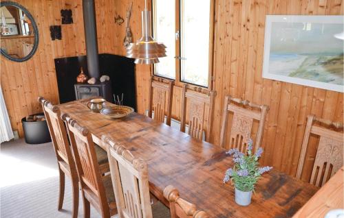 a dining room with a wooden table and chairs at Holiday Home Svenstibakkevej Frøstrup in Lild Strand
