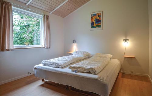 a bed in a room with a window at Stunning Home In Ebeltoft With Sauna, Wifi And 3 Bedrooms in Ebeltoft