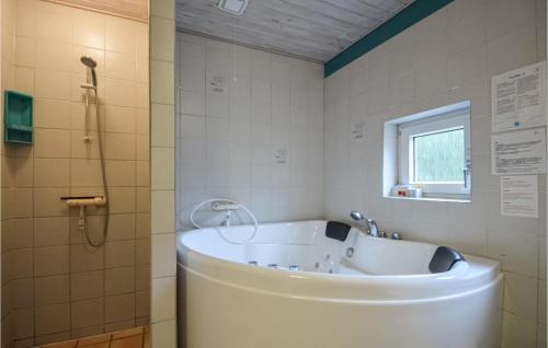 ロモ・キルケビーにあるStunning Home In Rm With Saunaのバスルーム(白いバスタブ、シャワー付)
