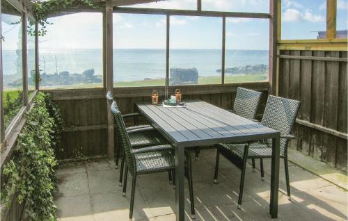 a table and chairs on a balcony with a view of the ocean at Holiday Home Spodsbjergvej I in Spodsbjerg