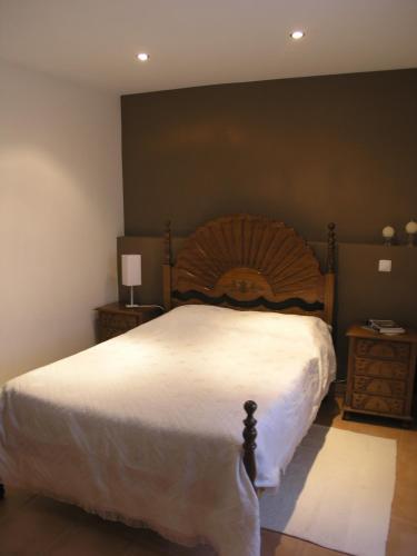 a bedroom with a large bed with a wooden headboard at Casa Nazare in Vilar Torpim
