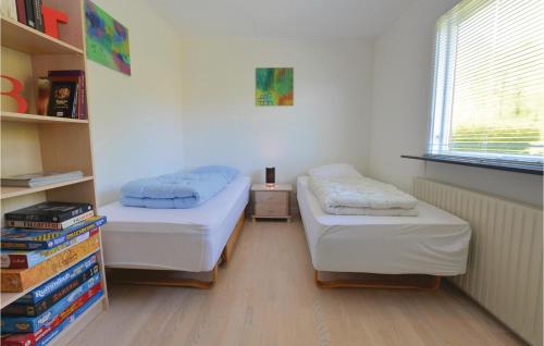 AugustenborgにあるBeautiful Home In Augustenborg With 3 Bedrooms And Wifiのベッドルーム(ベッド2台、本棚付)
