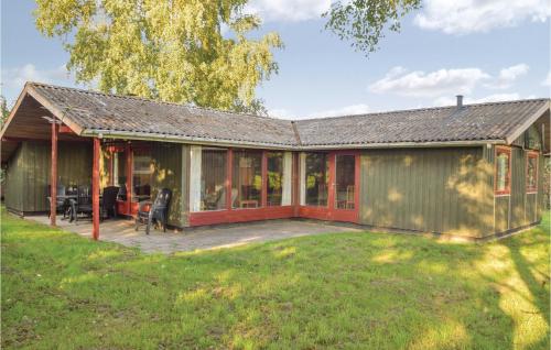 a green house with a deck and a yard at Holiday Home Odder With A Fireplace 07 in Kysing