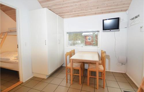 ヒュールスミンネにあるJuelsminde Campinghytteのテーブル、椅子、ベッドが備わる小さな客室です。