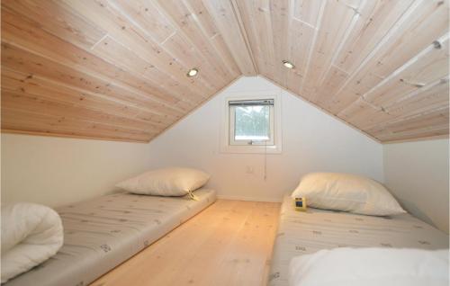 ヒュールスミンネにあるJuelsminde Campinghytteの木製天井のドミトリールームのベッド2台分です。