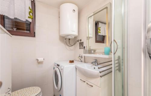 uma casa de banho branca com um lavatório e uma máquina de lavar roupa em Cozy Home In Prezid With Wifi em Prezid