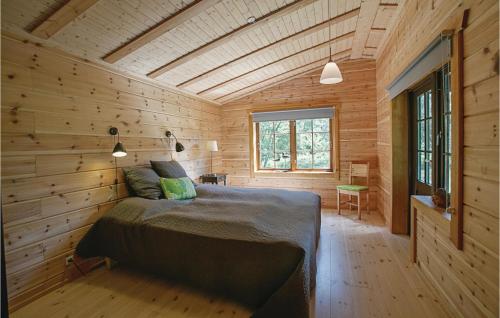 Spidsegård的住宿－蒙可加的斯科文內克索十號度假屋，木制客房内的一间卧室,配有一张床