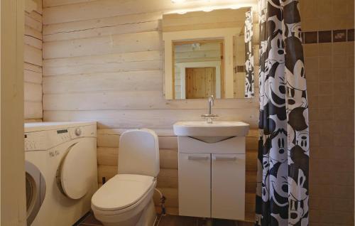 a bathroom with a toilet and a sink and a mirror at Holiday Home Frederiksvej Nexø Denm in Balke